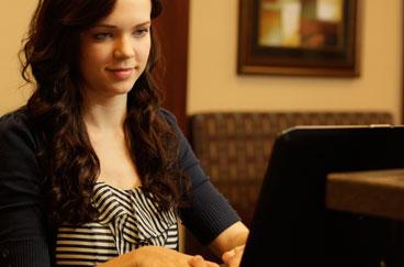 Woman sitting at home looking at her computer.